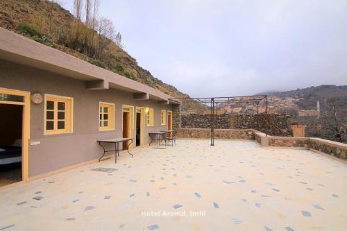 a patio with a table and chairs and a building at Hotel Igoudar Armed in Imlil
