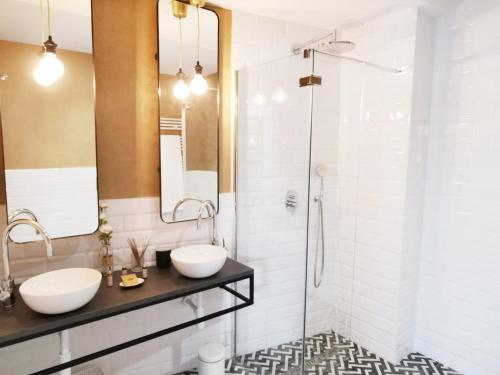 a bathroom with two sinks and a shower at Apartamentos Tres Llaves Palacio de Vela de los Cobos in Úbeda