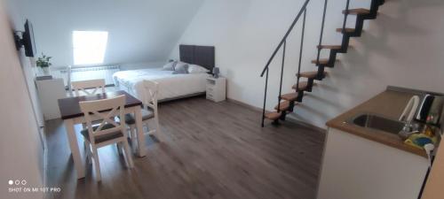a small room with a table and a bed and stairs at Noclegi Szymrych in Chełmsko Śląskie