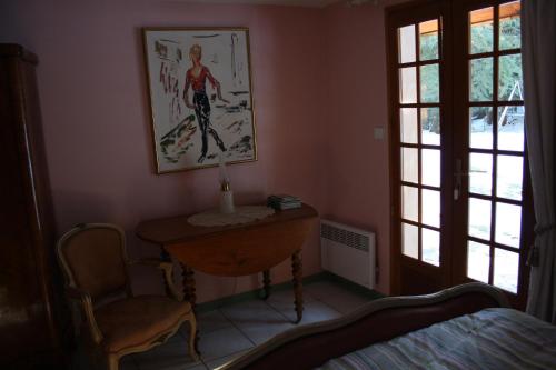 1 dormitorio con mesa y una foto en la pared en Le Pra d'Alart, en La Bollène-Vésubie