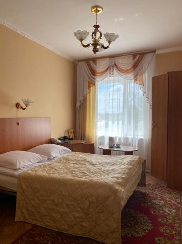 a bedroom with a large bed and a window at Отель Ак Булак in Borovoye