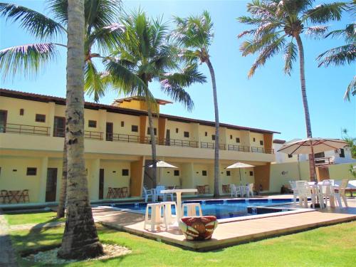 un complejo con piscina y palmeras en Pousada Paraiso da Barra, en Barra de Santo Antônio