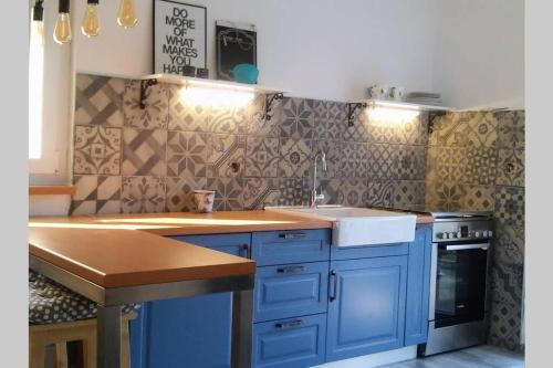 a kitchen with blue cabinets and a sink at Kati 1 in Sveti Filip i Jakov