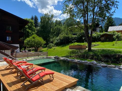 a group of chairs sitting next to a swimming pool at Hotel zur Post in Goldegg