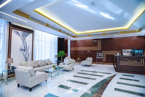 sala de estar con sofá, sillas y piano en The Gate Hotel and Apartments en Dammam
