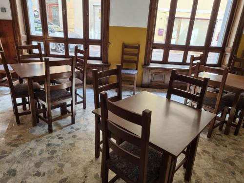 un comedor con mesas, sillas y ventanas en Albergo Spina en Pontebba