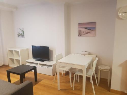 sala de estar con mesa blanca y TV en Apartamento Miñoca con Garaje, en Vigo