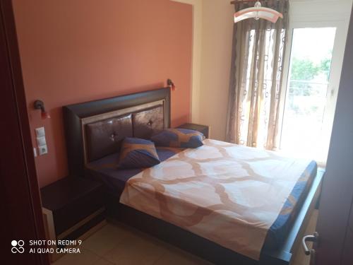 a bedroom with a large bed with a window at GIORGOS LUX APARTMENTS in Volos