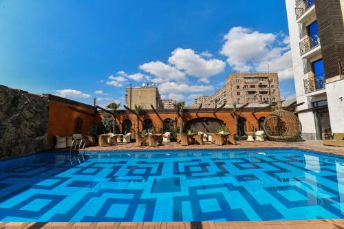 a swimming pool with blue tiles on the side of a building at Konyak Hotel in Yerevan
