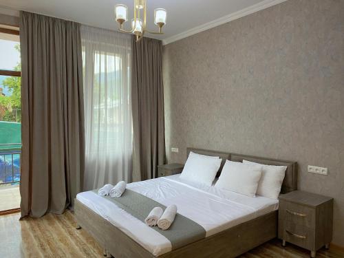a bedroom with a bed with white slippers on it at Central Kvareli in Kvareli