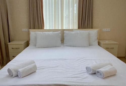 a white bed with towels on top of it at Central Kvareli in Kvareli