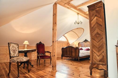 um quarto com uma cama, uma mesa e um espelho em Impresja - pokoje gościnne na nadbużańskich łąkach em Borsuki