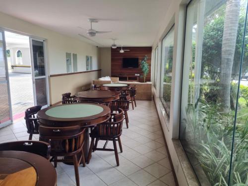 a restaurant with tables and chairs and a patio at Villa Giardino - Condomínio de Frente para o Mar - Piscina, Quadra Esportiva, Churrasqueira - 5 Pessoas in Florianópolis