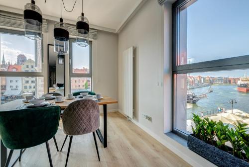 a dining room with a table and a large window at The Black Crane Apartment in Gdańsk