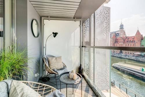 an apartment balcony with a view of the river at The Black Crane Apartment in Gdańsk