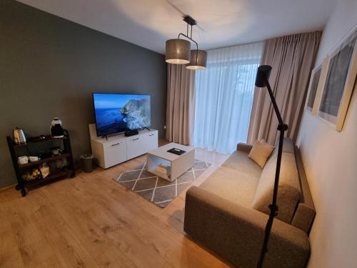a living room with a couch and a flat screen tv at Monte Amnis Apartment in Štrbské Pleso