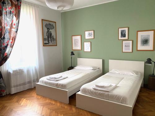 2 letti in una camera da letto con pareti verdi e finestra di Cà Giulia a Venezia