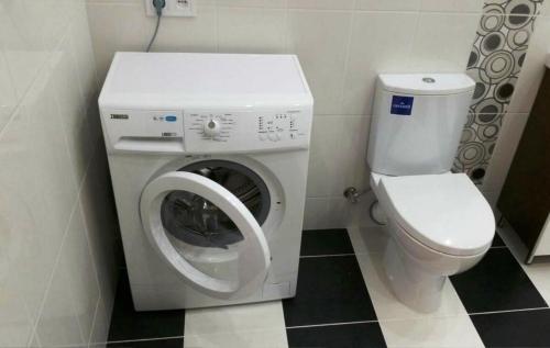 a bathroom with a washing machine and a toilet at Nikolaev City Center in Mykolaiv