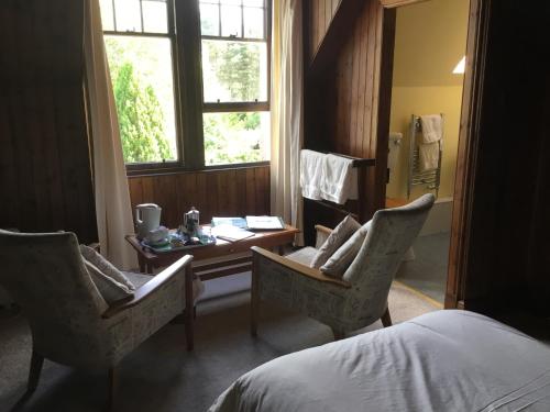 a bedroom with a desk and two chairs and a bed at Westward Bed and Breakfast in Cannich