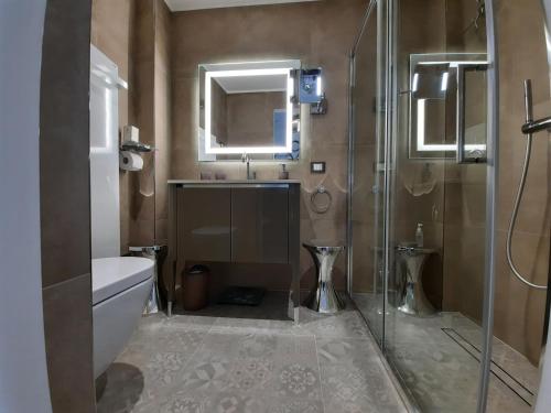a bathroom with a shower and a sink and a toilet at Palms Luxury Suites Sanremo in Sanremo