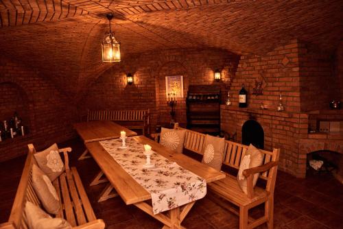 a dining room with a wooden table and chairs at Impresja - pokoje gościnne na nadbużańskich łąkach in Borsuki