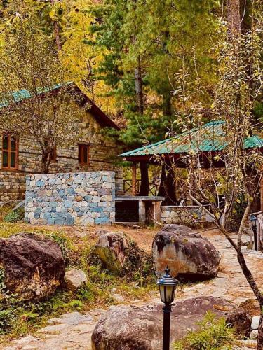 a stone house with a street light in front of it at Tirthan Anglers' Retreat in Banjār