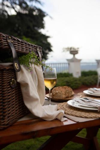 a picnic table with a basket and a glass of wine at Daleside Manor, Boutique Hotel, Kasauli in Kasauli