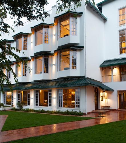 a large white house with a green lawn at Daleside Manor, Boutique Hotel, Kasauli in Kasauli
