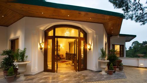 an entry to a house with a large glass door at Daleside Manor, Boutique Hotel, Kasauli in Kasauli