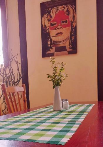 a vase with flowers on a table with a painting at Holiday Ozon in Sztutowo