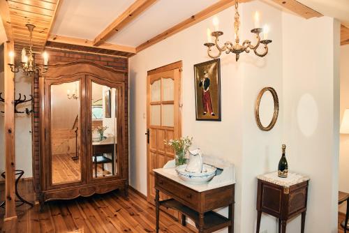 Zimmer mit einem Tisch und einem Kronleuchter in der Unterkunft Impresja - pokoje gościnne na nadbużańskich łąkach in Borsuki