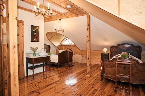a room with a bed and a desk and a staircase at Impresja - pokoje gościnne na nadbużańskich łąkach in Borsuki