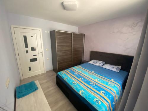 um pequeno quarto com uma cama e uma cabeceira em madeira em Двустаен апартамент в центъра на Русе em Ruse