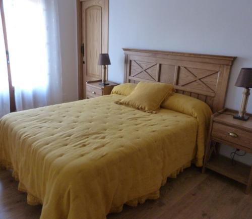 a bedroom with a large bed with a yellow blanket at Hotel Rural - La Osa Mayor - 4 Estrellas in Villasrubias