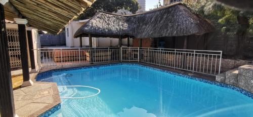 a large blue swimming pool with a gazebo at Lytton Cresent B&B in Pinetown