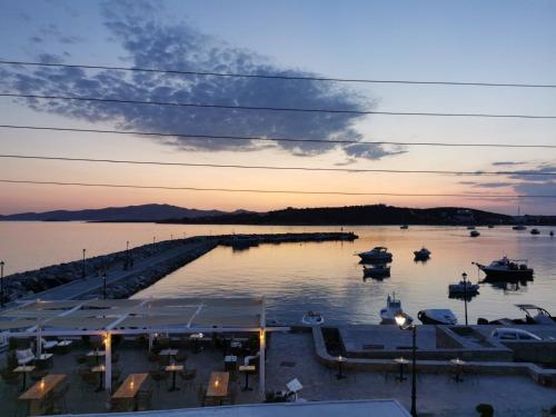 a marina with boats in the water at sunset at KR Apartments in Aliki