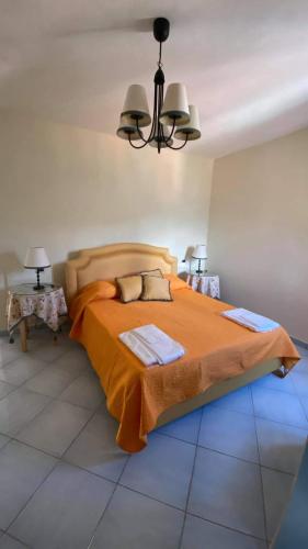 a bedroom with a bed with an orange blanket at Monolocale & Suite Casa Santicelli Maratea in Maratea