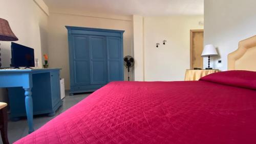 a bedroom with a red bed and a blue cabinet at Monolocale & Suite Casa Santicelli Maratea in Maratea