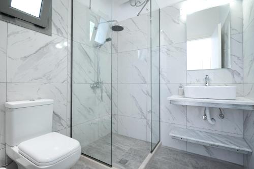 bagno bianco con servizi igienici e lavandino di Marina Vista Luxury Studio suites Beach front a Città di Corfù