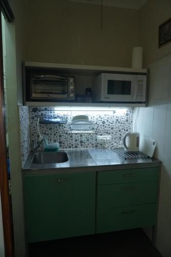 a small kitchen with a sink and a microwave at Passion Fruit Apartment in Ashkelon