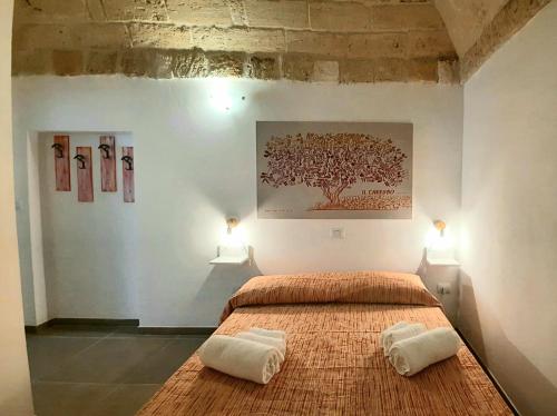 een slaapkamer met een bed met twee handdoeken erop bij I Due Carrubi in Ostuni