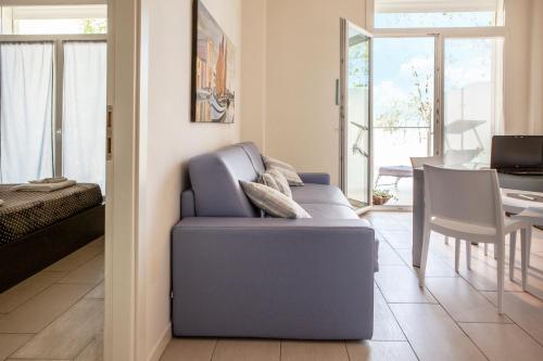 a living room with a blue couch and a table at Residence Sunrise in Cesenatico
