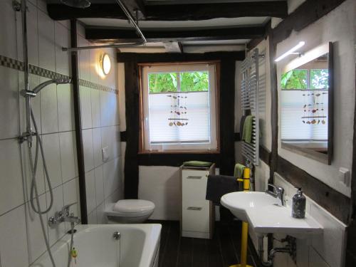 La salle de bains est pourvue d'une baignoire, de toilettes et d'un lavabo. dans l'établissement Ferienhaus Zum alten Standesamt, à Weenzen