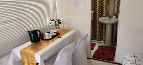a table with chairs and a sink in a room at Lytton Cresent B&B in Pinetown