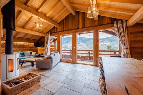 a living room with a fireplace in a log cabin at Chalet ''la cabane ô Pierres'' 12 pers spa et sauna in Ventron