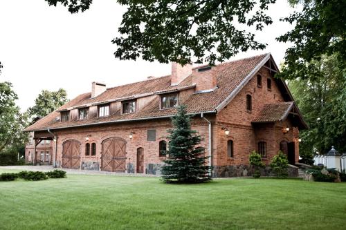 a large brick house with a green lawn at Ciekocinko Powozownia in Ciekocinko