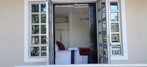 a room with a bed and two windows at Lytton Cresent B&B in Pinetown