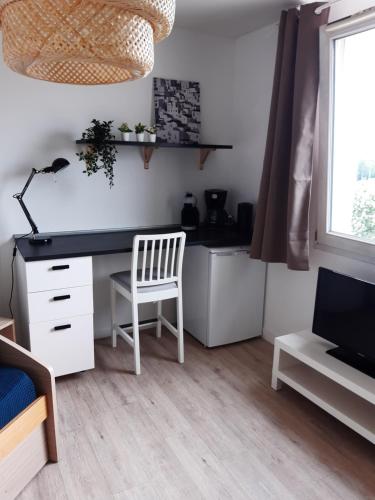 Zimmer mit einem Schreibtisch, einem Stuhl und einem Computer in der Unterkunft LE COCOON DE SAINT JEAN PROCHE CLINIQUE DE L UNION in Saint-Jean