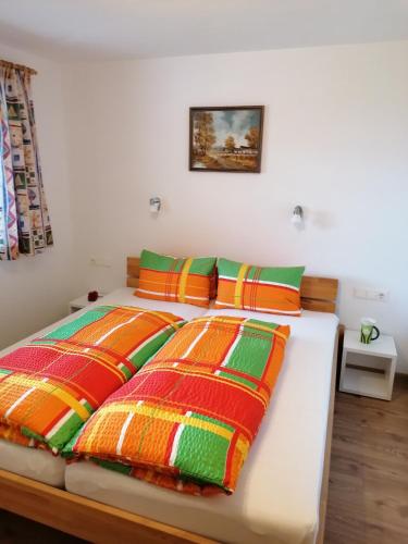 a bedroom with two beds with colorful blankets at Embacher Marianne - Rotharlhof in Hopfgarten im Brixental
