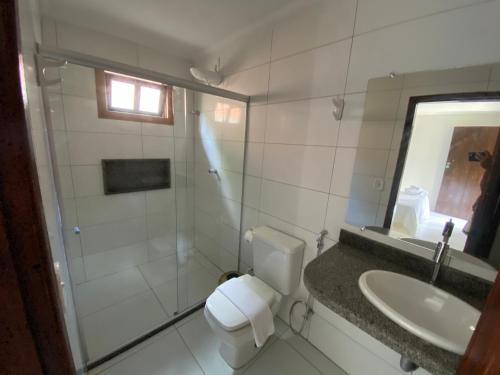 a bathroom with a shower and a toilet and a sink at Pousada Casa de Maria Bonita in Arraial d'Ajuda